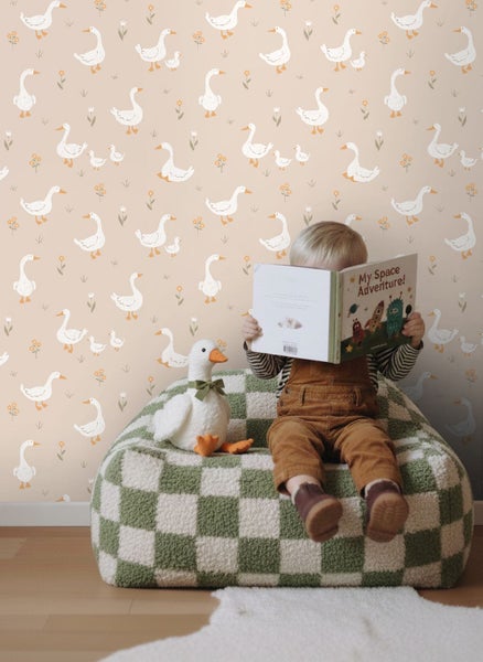 Kinderzimmer mit Tapete mit Gänsemuster, Kindersitzsack und Kind, das ein Buch liest