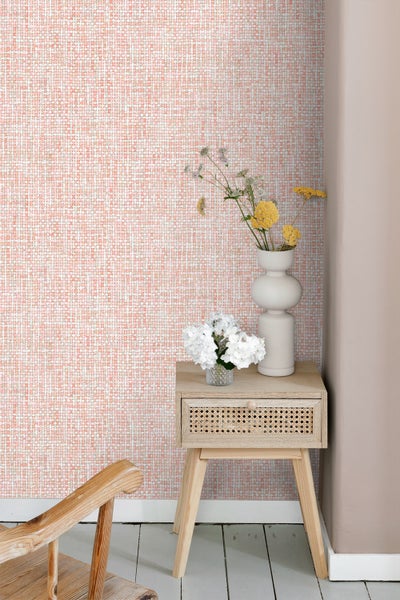 Raumansicht mit gemusterter Tapete und Beistelltisch aus Holz mit Blumenvasen