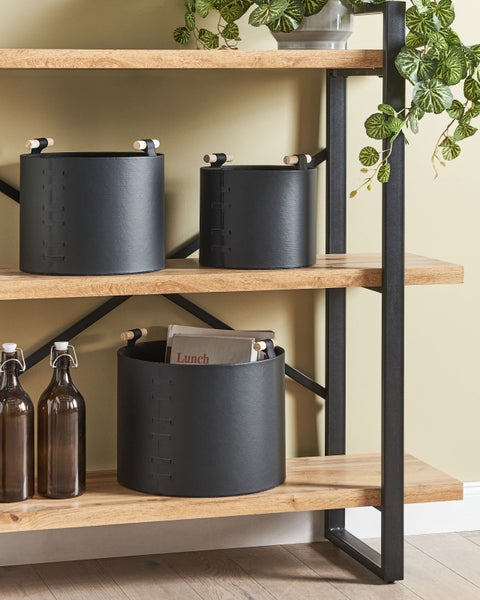 Schwarze Aufbewahrungskörbe aus Kunstleder mit Holzgriffen auf einem Holzregal mit Metallrahmen, organisiertes Wohnambiente.