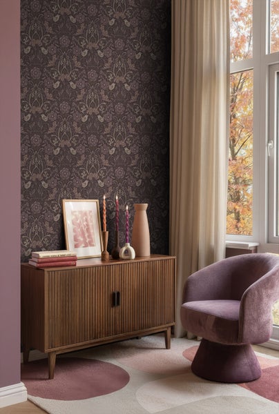 Wohnzimmer mit dunkler gemusterter Tapete, Holzkommode, Dekoration und Sessel