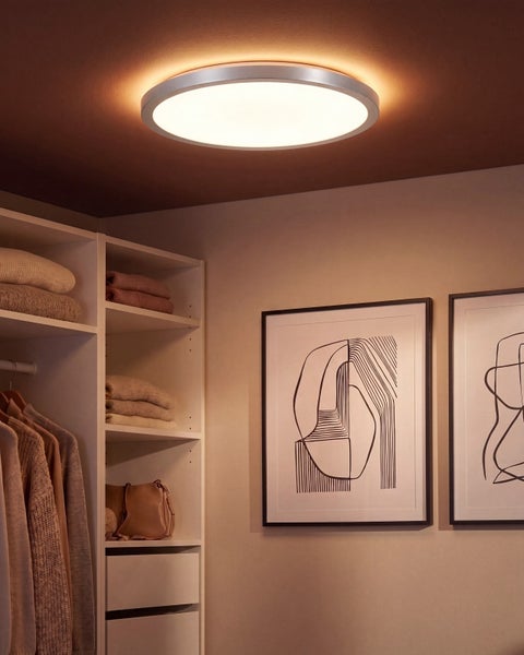 Runde LED Deckenleuchte in einem Ankleidezimmer mit Regalen und Wandbildern.