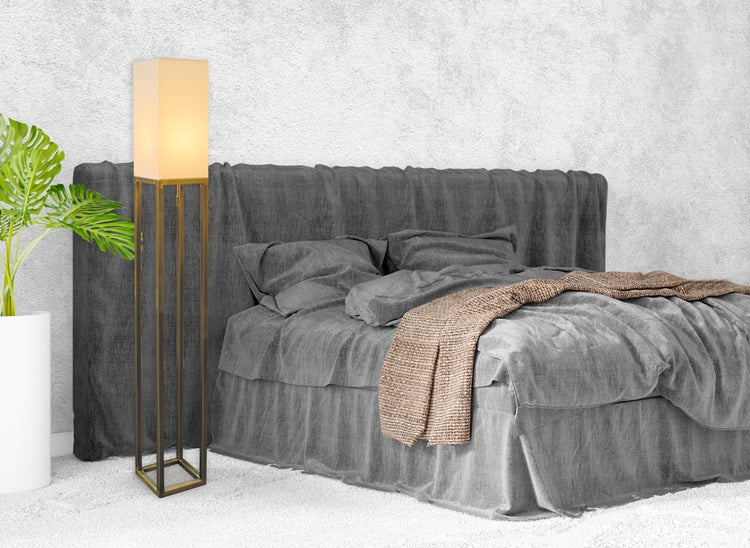 Schlafzimmer mit Bett, Stehlampe und Zimmerpflanze