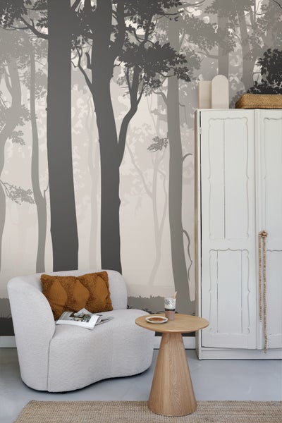 Wohnzimmer mit Waldtapete, Sessel, Beistelltisch und Schrank für ein gemütliches Ambiente