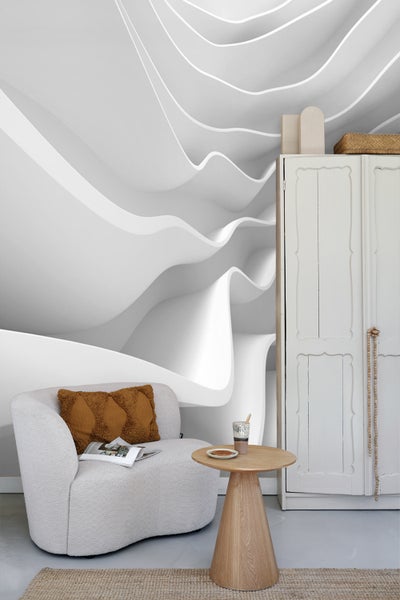 Wohnzimmer mit Sessel, Beistelltisch, Schrank und abstrakter Tapete