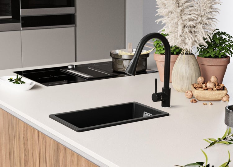 Küchenszene mit Spüle, Armatur und Kochfeld in einer hellen und modernen Umgebung.