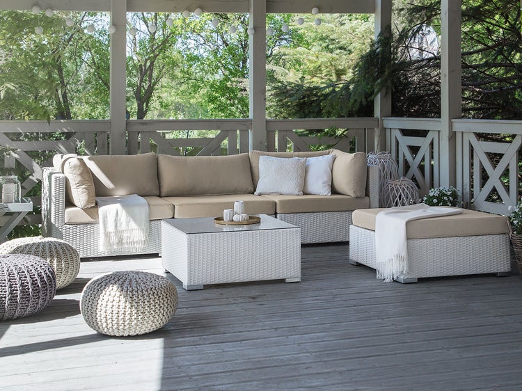 Terrasse mit Rattanmöbeln, bestehend aus Sofa, Tisch und Hockern