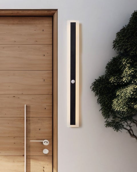 Wandleuchte mit Bewegungsmelder neben einer Holztür und einer Pflanze