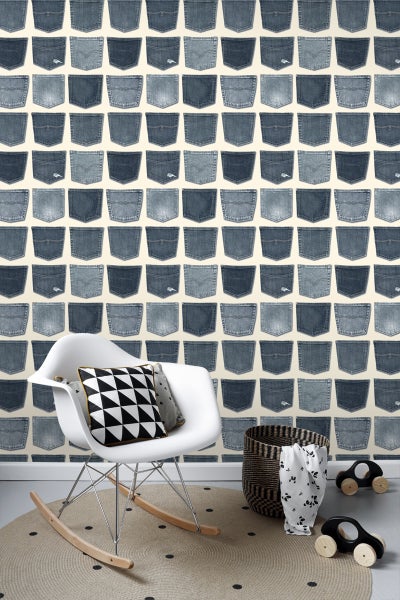 Wohnraum mit Jeanshosentaschen-Tapete, Schaukelstuhl, Korb und Spielzeugautos.