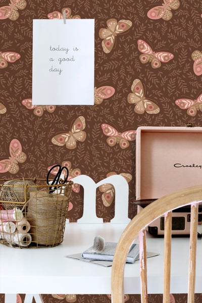 Dekoratives Zimmer mit brauner Schmetterlingstapete, Tisch, Accessoires und Stuhl.