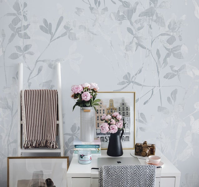 Dekorative Szene mit Leiter, Tisch und floraler Tapete für ein gemütliches Ambiente