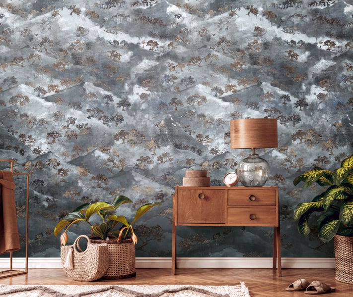 Szene mit gemusterter Tapete, Holzkommode, Tischlampe und Zimmerpflanzen in Körben