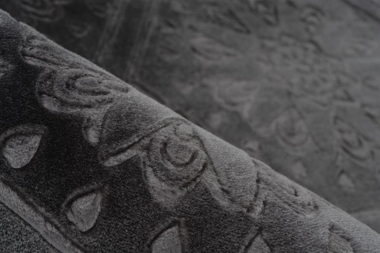 Detailaufnahme eines weichen Teppichs mit geprägtem Ornamentmuster.