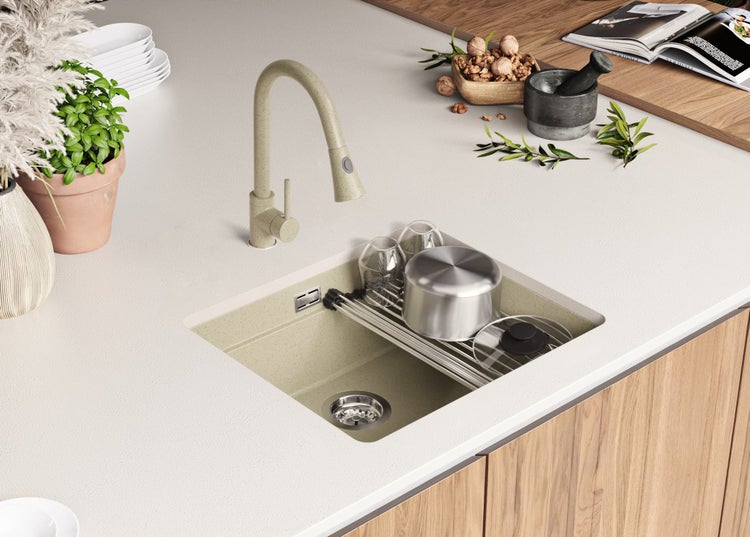 Küchenspüle mit Abtropfgestell, Armatur und Spülbecken auf einer Küchentheke.