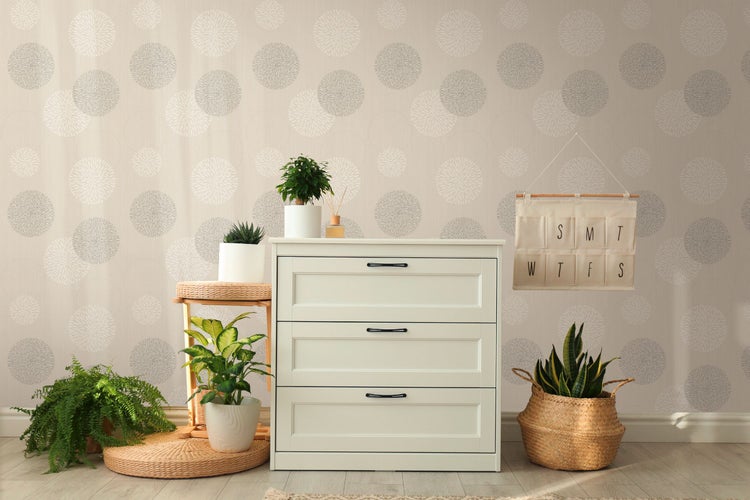 Helles Schlafzimmer mit gemusterten Tapeten, Bett und Holzmöbeln