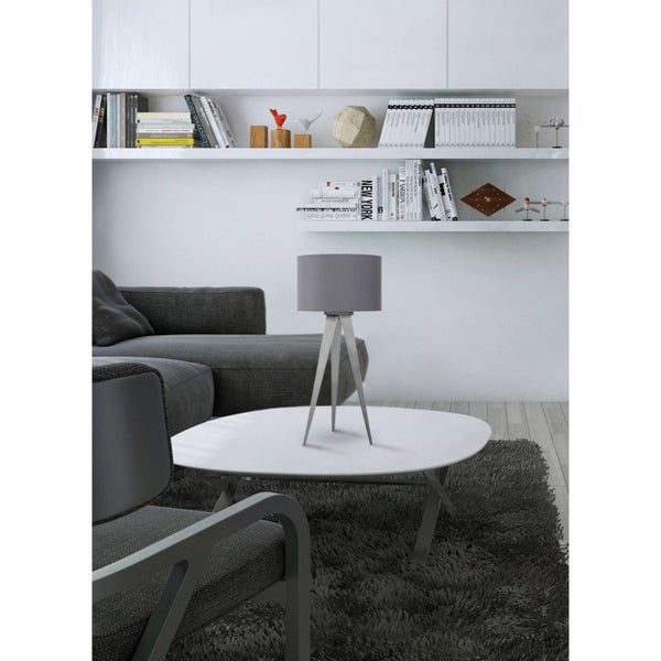 Modernes Wohnzimmer mit grauem Sofa, weißem Couchtisch und grauer Tischleuchte mit Stativfuß vor einem Bücherregal.