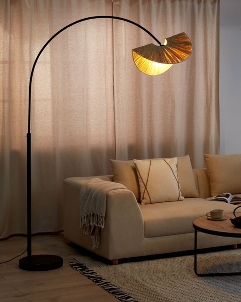 Wohnzimmer-Szene mit Stehlampe, Sofa, Kissen, Teppich und Beistelltisch.