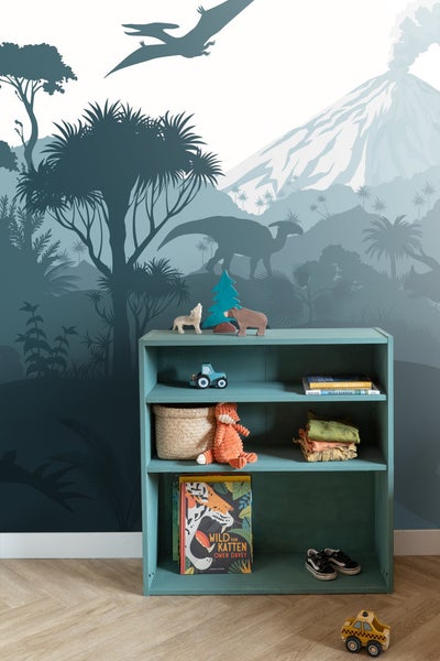 Regal mit Spielzeug und Büchern vor einer Wandtapete mit Dschungelmotiv