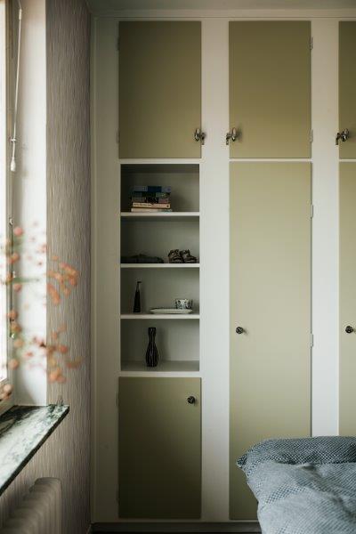 Ein Arbeiter benutzt einen Akku-Winkelschleifer, um ein Metallrohr zu schneiden, das in einem Schraubstock befestigt ist. Funken fliegen.