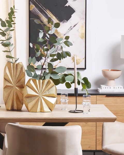 Esstischdekoration mit Vasen, Kerzenständer und Gläsern auf einem Holztisch