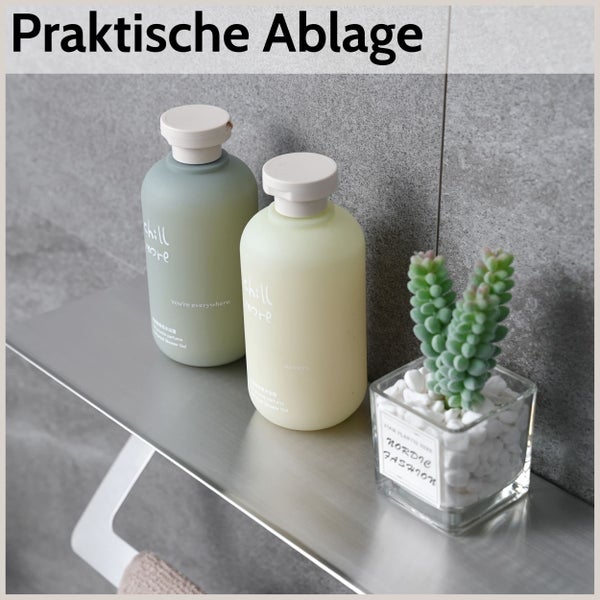 Praktische Wandablage aus Metall für das Badezimmer, montiert an einer Fliesenwand, dekoriert mit Duschgelflaschen und einer kleinen Pflanze.