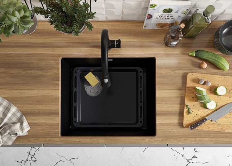 Draufsicht auf eine Küchenspüle mit Abtropfschale, Armatur und Küchenutensilien