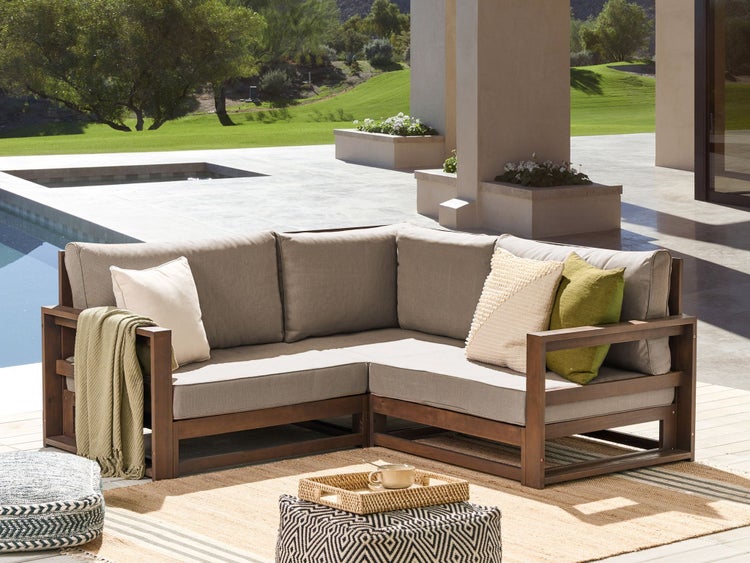 Ecksofa aus Holz mit Kissen und Beistelltisch im Freien