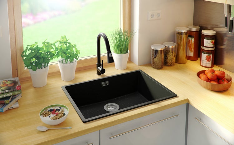 Spüle aus Granit mit Wasserhahn in einer hellen Küche.