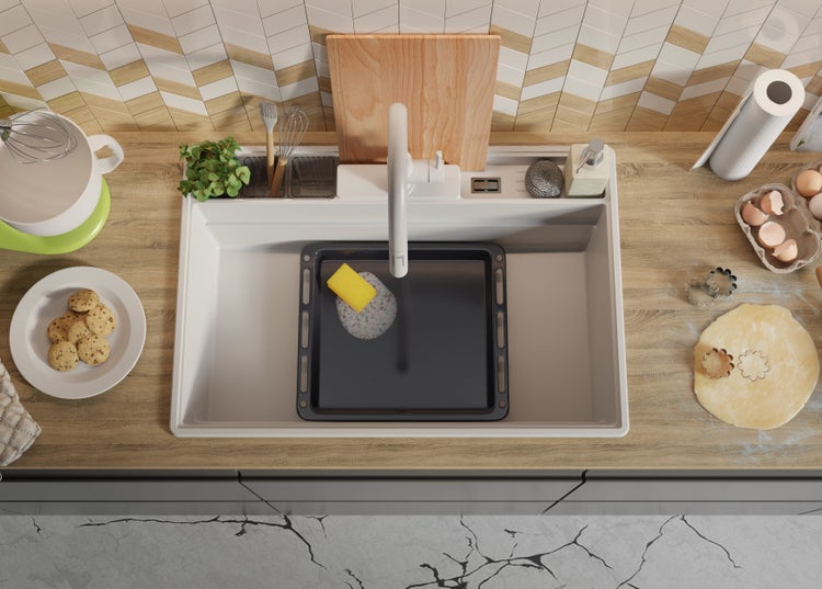 Küchenspüle mit Backblech, Spülmittel und verschiedenen Küchenutensilien auf einer Küchentheke.