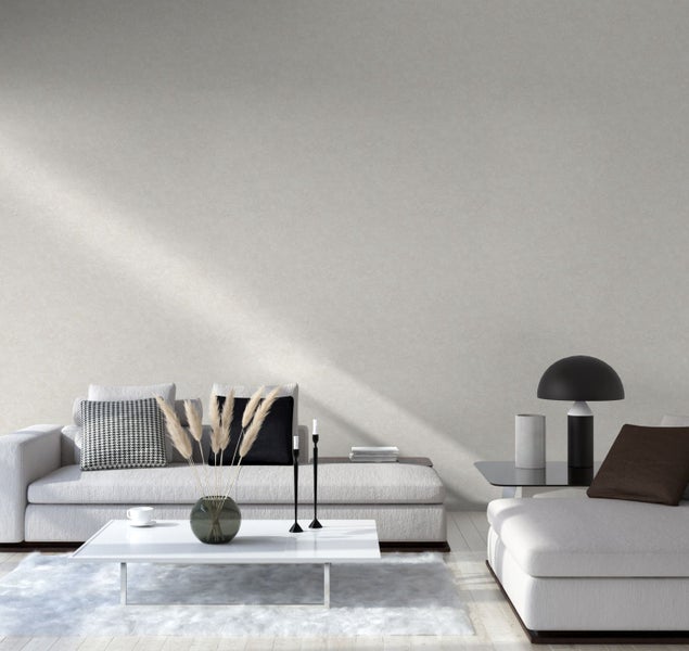 Zwei Tapetenrollen in einer Schale: eine mit Blattmuster, die andere mit Struktur.