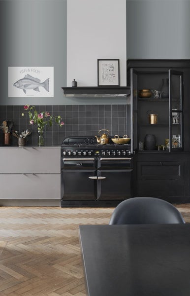 Küchenszene mit schwarzem Herd, Spüle und Dekoration