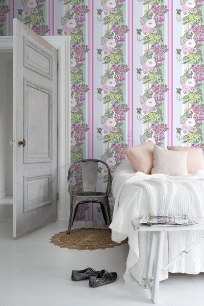 Dekoratives Schlafzimmer mit gestreifter Blumentapete, Bett und Tür