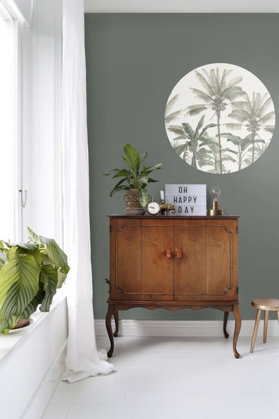 Dekoratives Zimmer mit Holzschrank und tropischem Wandtattoo