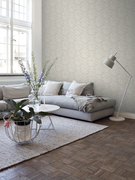 Wohnzimmer mit floral gemusterter Tapete, Sofa und Lampe.