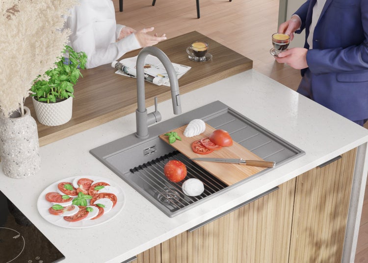 Küchenszene mit Spüle, Armatur, Schneidebrett, Mozzarella und Tomaten.