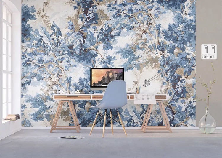 Hell gestaltetes Arbeitszimmer mit einer floralen Fototapete in Blau, einem Holzschreibtisch und einem modernen blauen Stuhl.