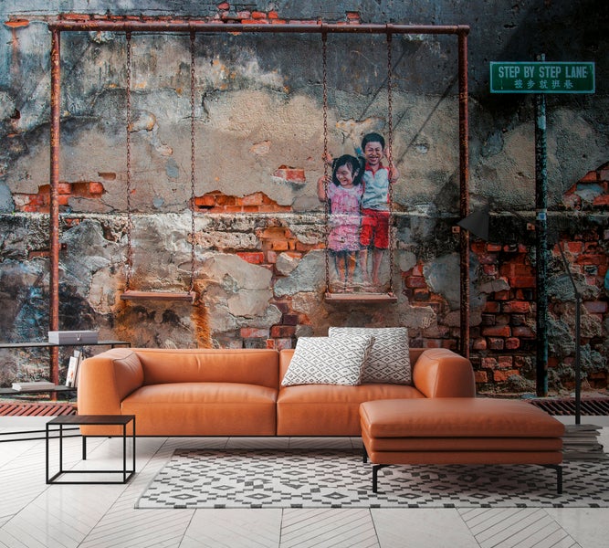 Fototapete mit Ziegelwand-Design und Illustration von Kindern auf einer Schaukel in einem modern eingerichteten Wohnzimmer mit Leder-Sofa.