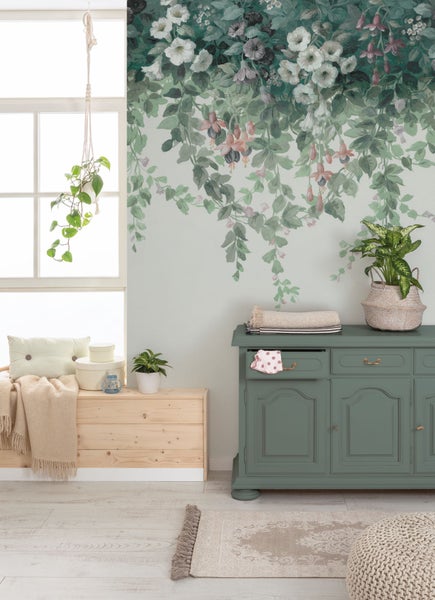 Dekoratives Interieur mit Blumenwandbild, Kommode und Zimmerpflanzen