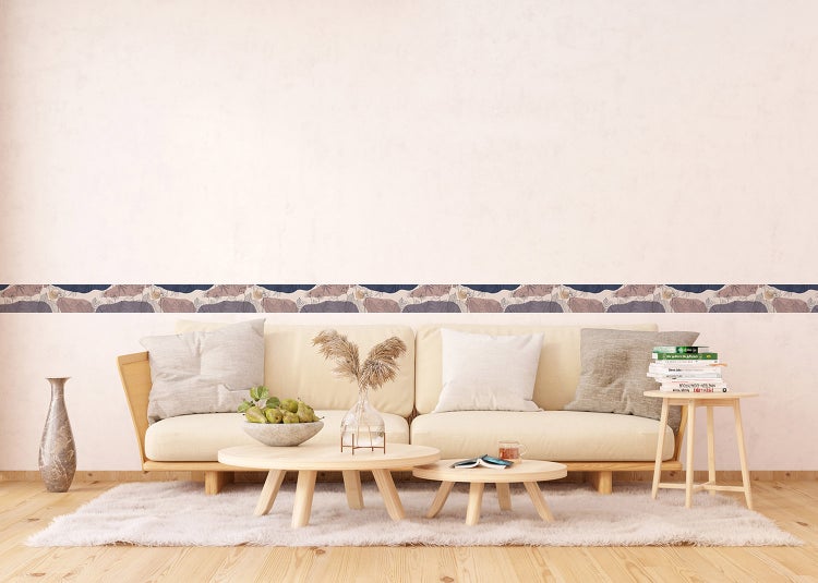 Tapetenbordüre mit abstraktem Muster in einem hellen, modernen Wohnzimmer über einem Sofa angebracht.