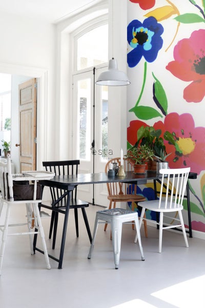 Esszimmer mit Esstisch, Stühlen und Blumendekoration an der Wand