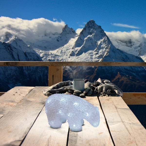 Dekoration Bär beleuchtet auf Holztisch mit Bergpanorama