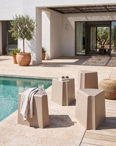Dreieckige Gartenhocker aus Kunststoff an einem Pool im Außenbereich mit mediterranem Design.