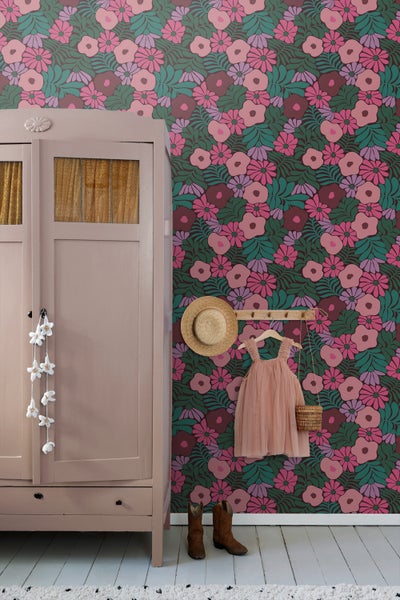 Dekorative Tapete mit floralem Muster hinter Tisch mit Lampe und Kamera