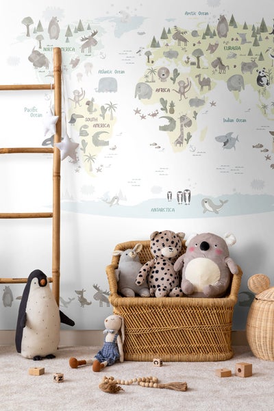 Kinderzimmerdekoration mit Weltkarte, Holzleiter und Stofftieren in einem Korb