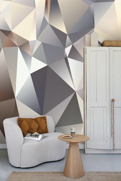 Wohnzimmer mit geometrischer Tapete, Sessel, Beistelltisch und Schrank