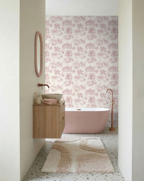 Modernes Badezimmer mit Safari Muster Tapete, freistehender rosa Badewanne, Holz Waschtisch und hellem Terrazzoboden.