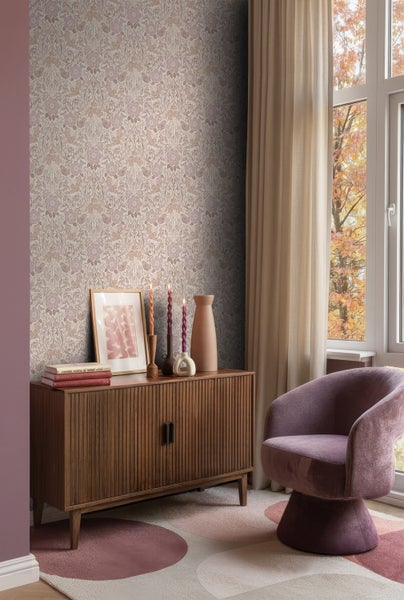 Dekoratives Wohnzimmer mit floraler Tapete, Holzkommode und Sessel