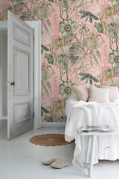 Schlafzimmer mit floraler Tapete, Bett, Beistelltisch, Teppich und offener Tür