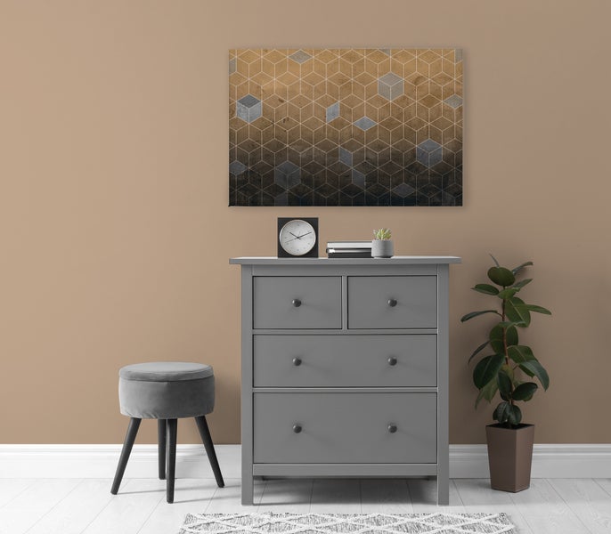 Einrichtungsszene mit einer grauen Kommode, einem Hocker, einer Zimmerpflanze und einem abstrakten Wandbild mit geometrischem Muster.