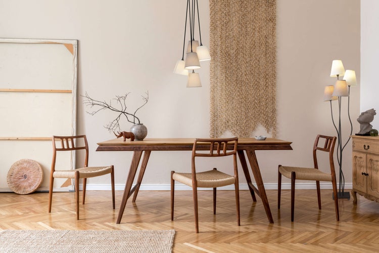 Esszimmer mit Holztisch und Stühlen, dekorativer Wandbehang und Beleuchtung für eine gemütliche Atmosphäre.