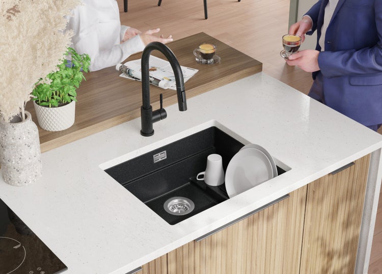 Küchenspüle mit Armatur und Geschirr auf einer Arbeitsplatte